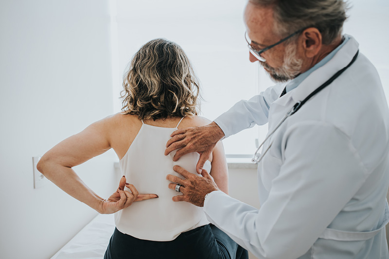 Patient showing doctor what part of her back hurts