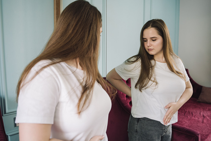 Women examining herself in the mirror