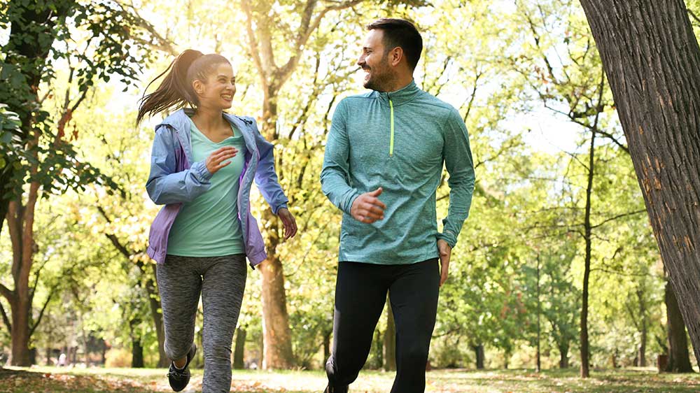 young couple running on path at park