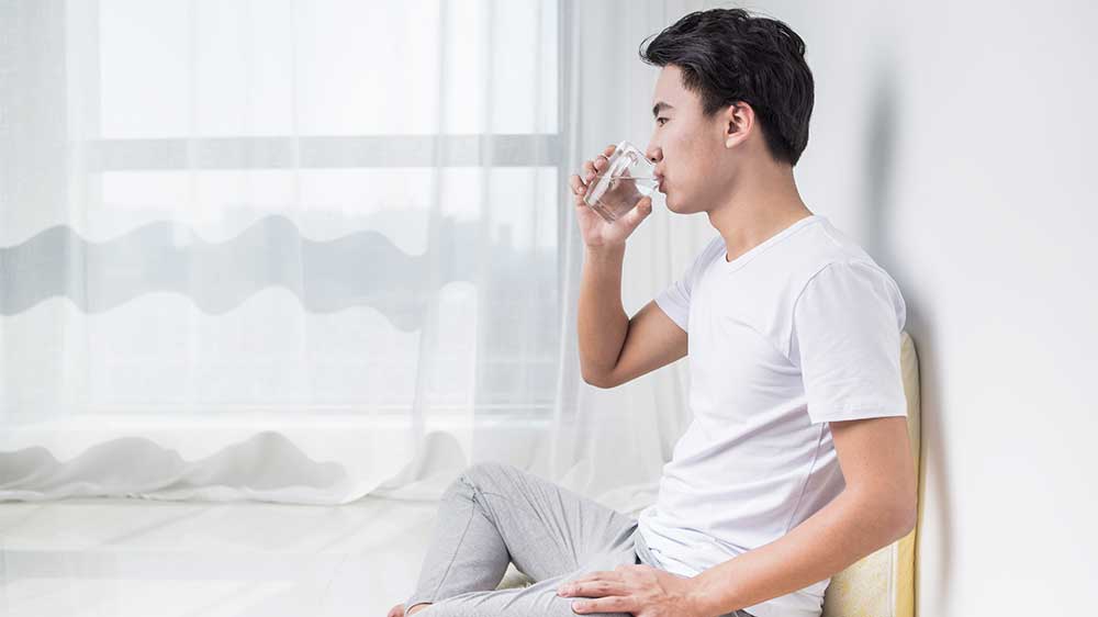 man drinking glass of water